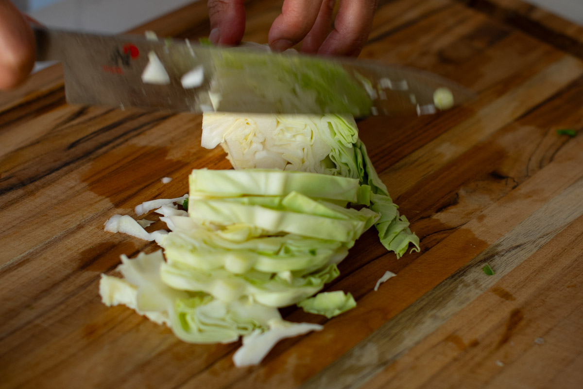 Fresh cabbage being sliced for Vegetarian Cambodian Chow Mein recipe.